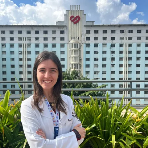 Dra. Raquel Cosso de jaleco em frente ao Hospital Madre Teresa